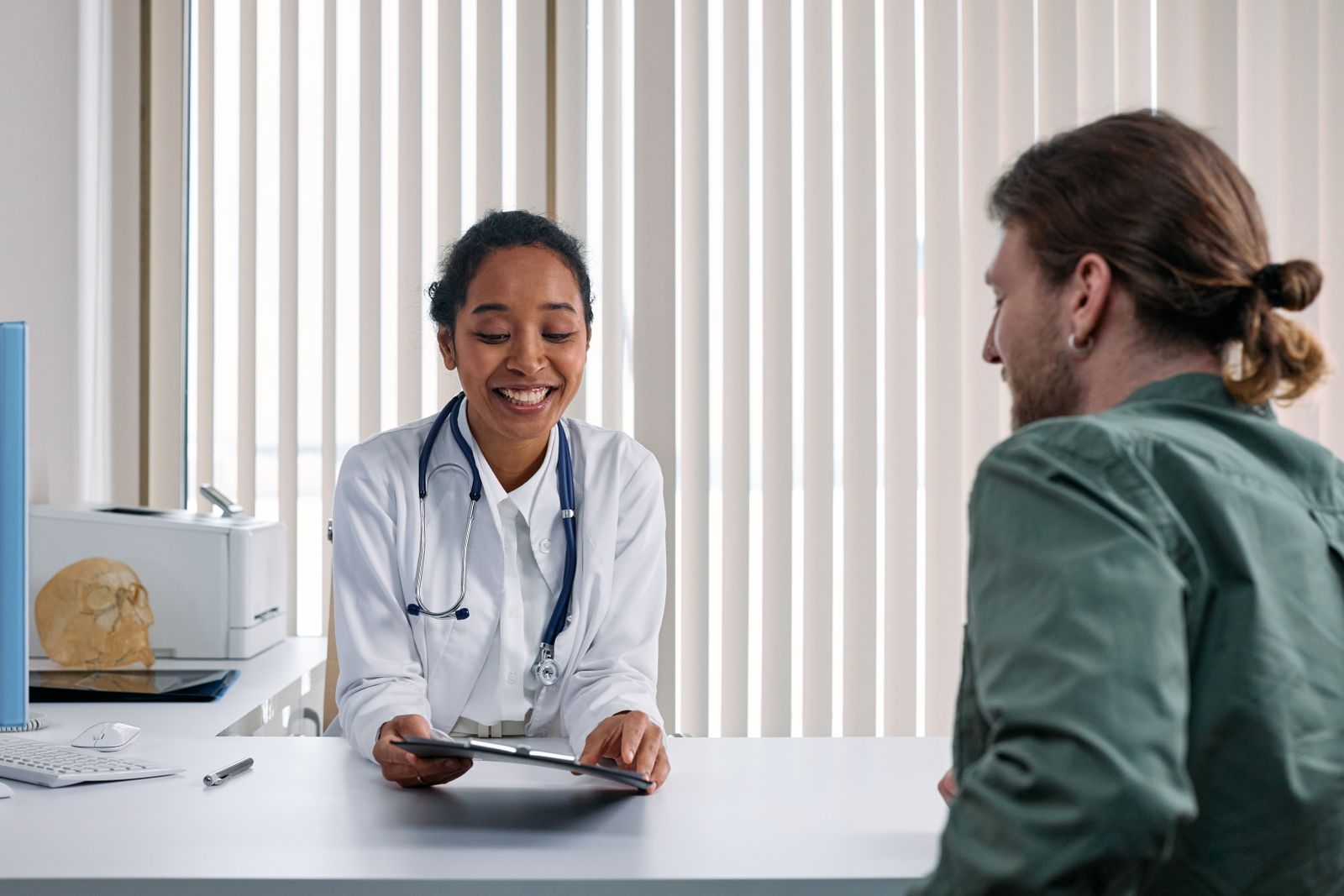 Primary care provider speaking with a patient during a consultation in a bright clinic.